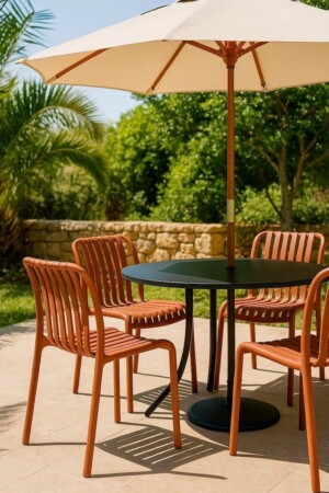 Mesa redonda de exterior con cuatro sillas de polipropileno color terracota y sombrilla beige en jardín.